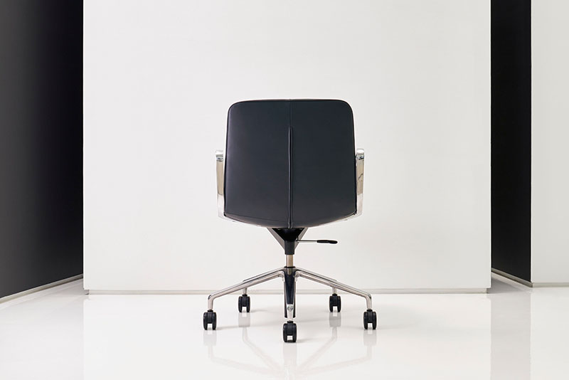 Back view of the Swav low back conference chair in front of a white wall
